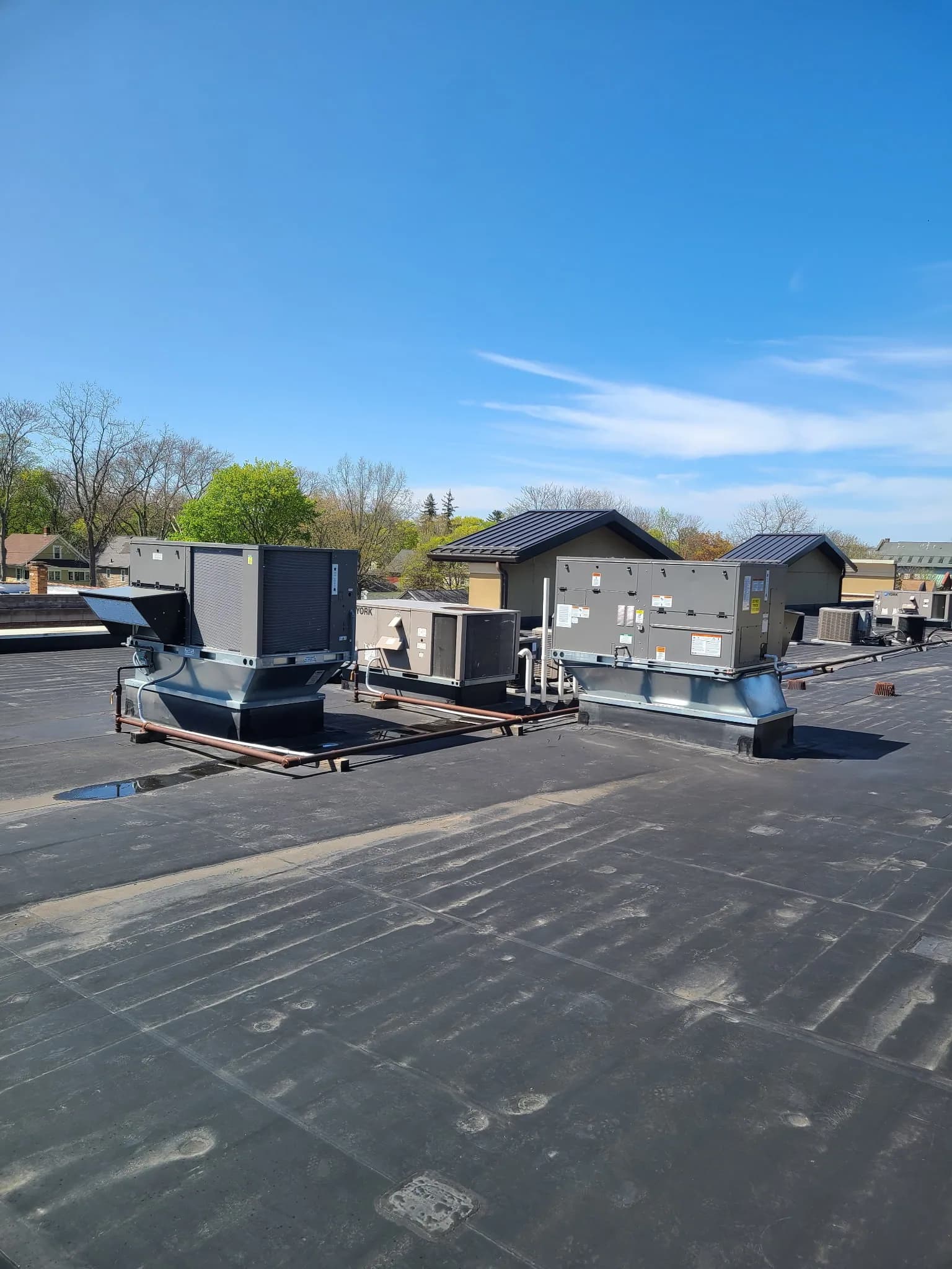 Completed commercial rooftop with multiple packaged HVAC units, gas piping, and curb-mounted equipment — 4th Gen install.