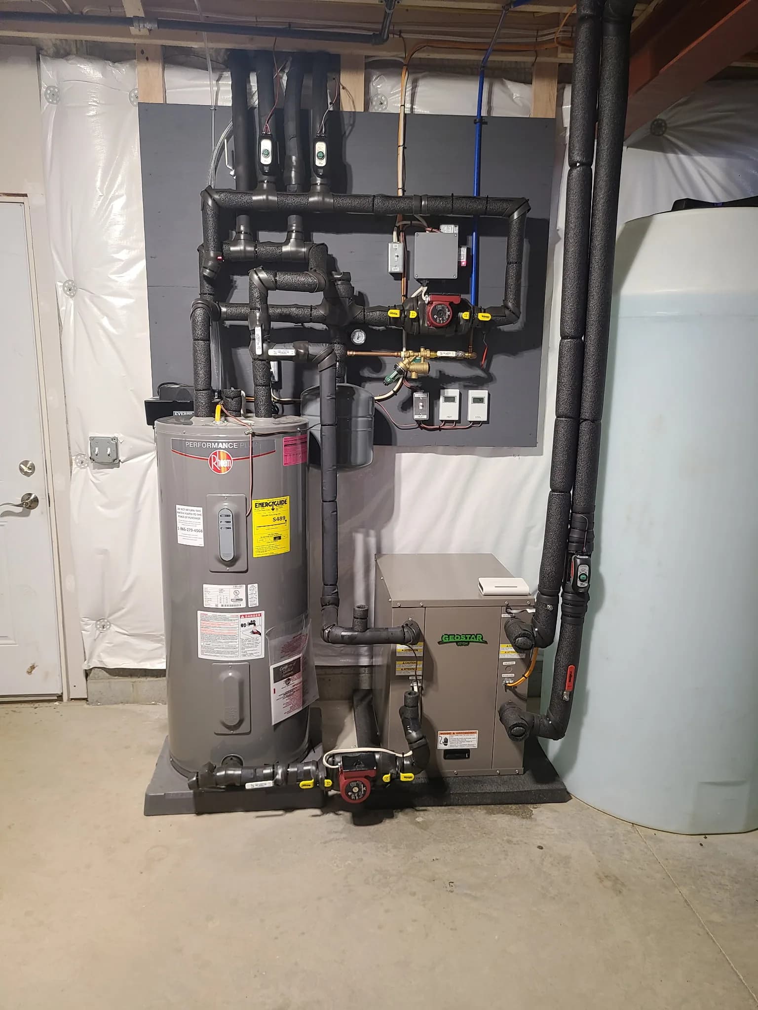 Clean residential mechanical room with GeoStar geothermal unit and labeled hydronic piping — 4th Gen Mechanical install.